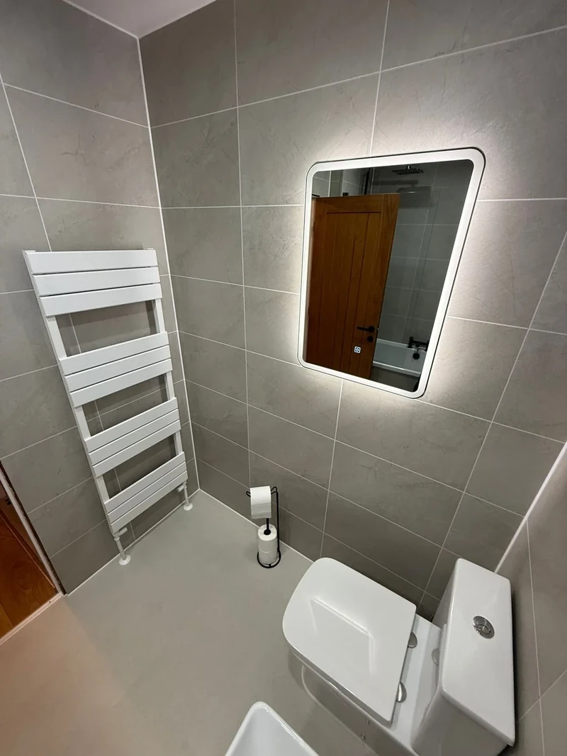 Completed bathroom with warm wood-effect finishes and shower