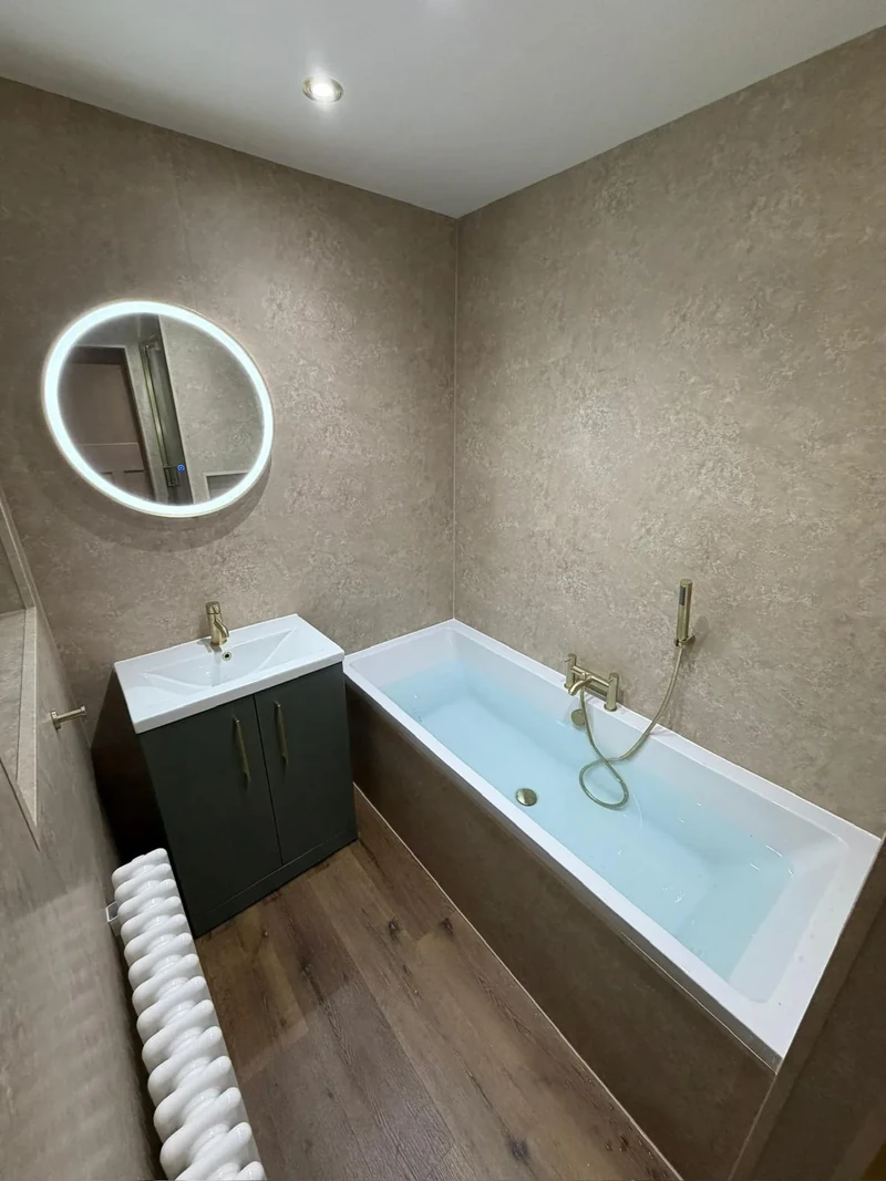 Completed bathroom with vanity unit, illuminated mirror and shower